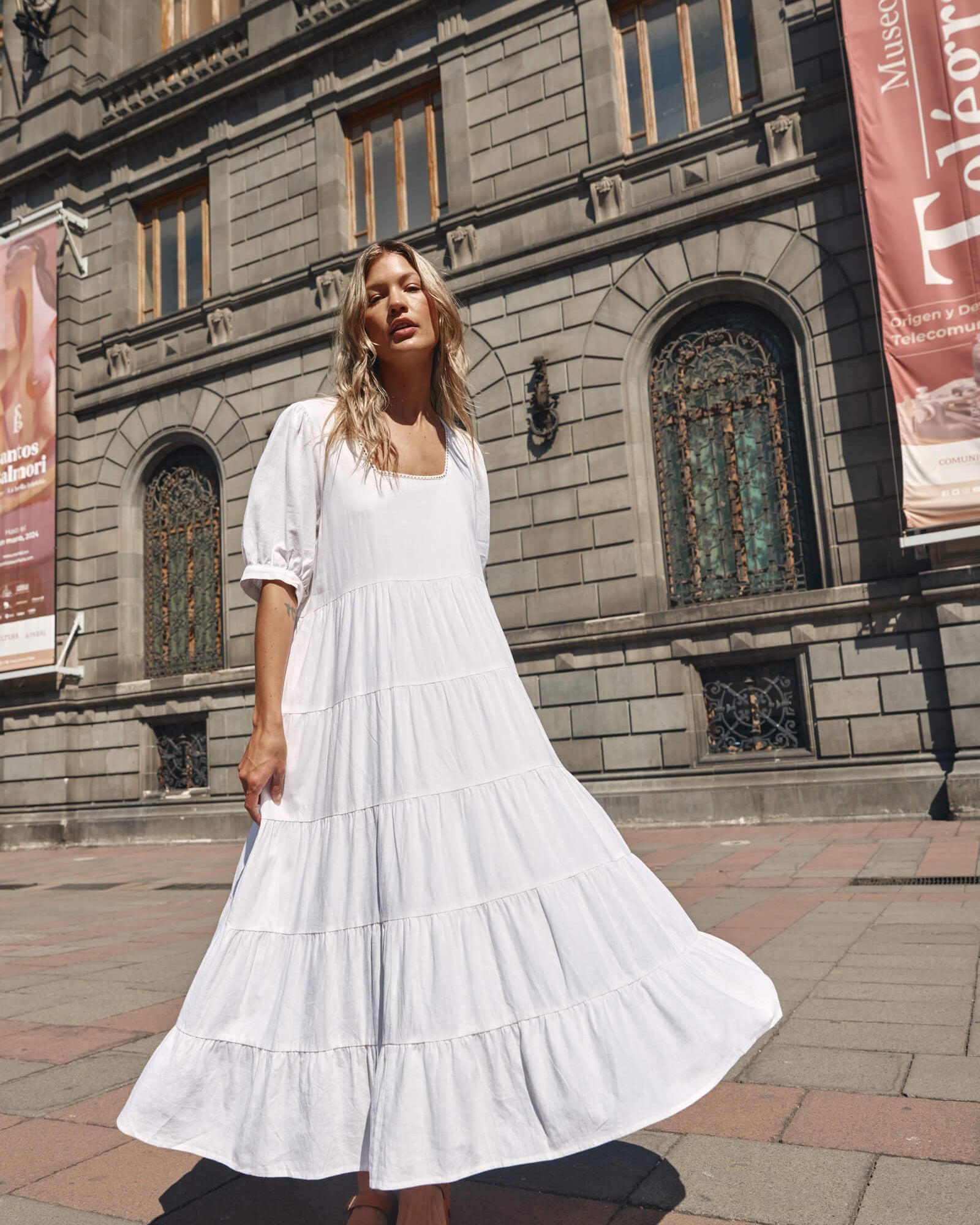 Lady in a white dress infront of a building