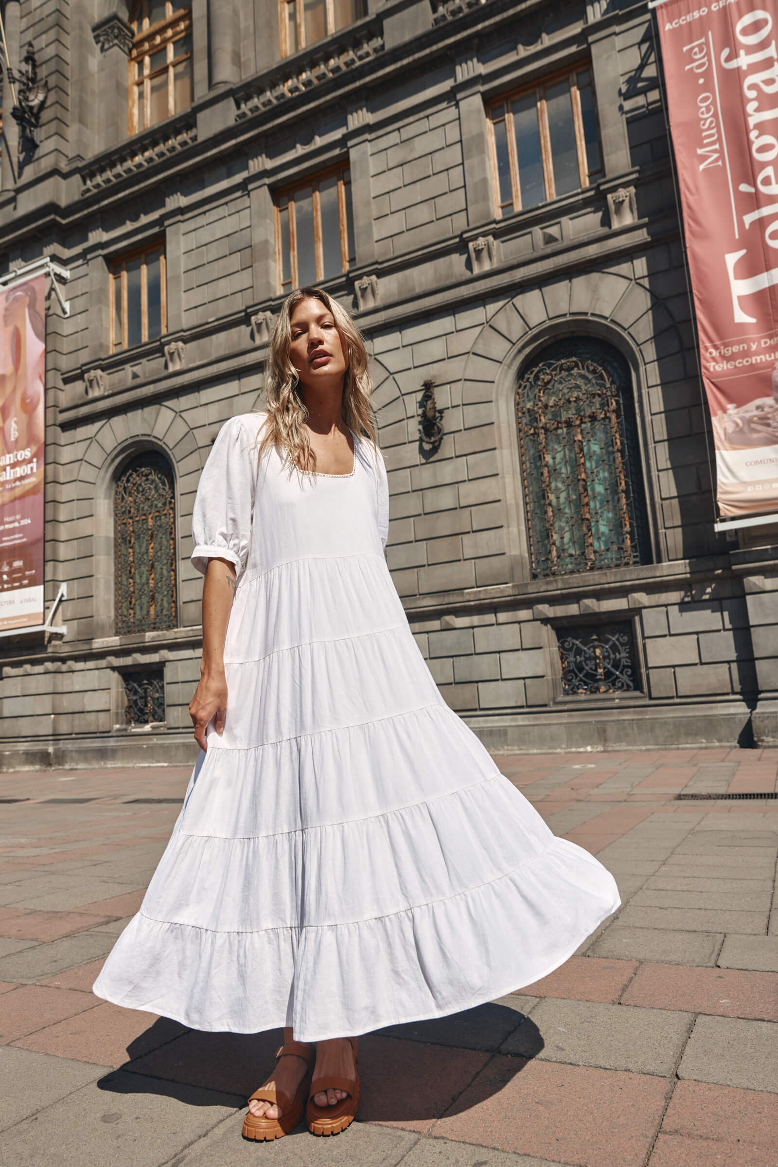 Lady in a white dress infront of a building