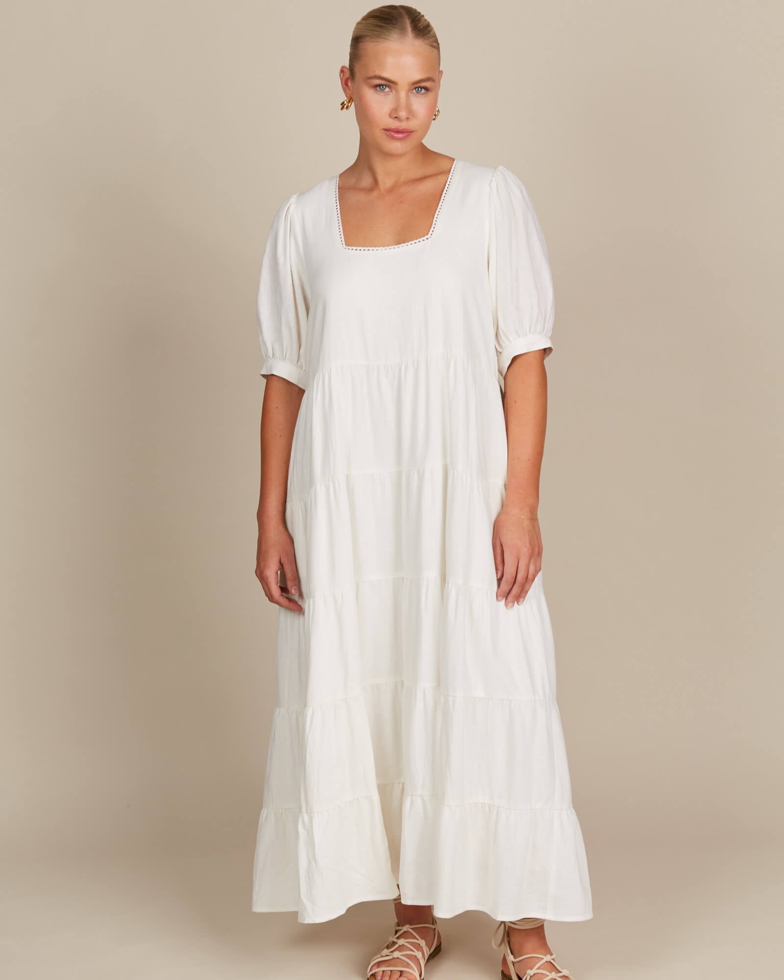 Model in white tired flowy dress