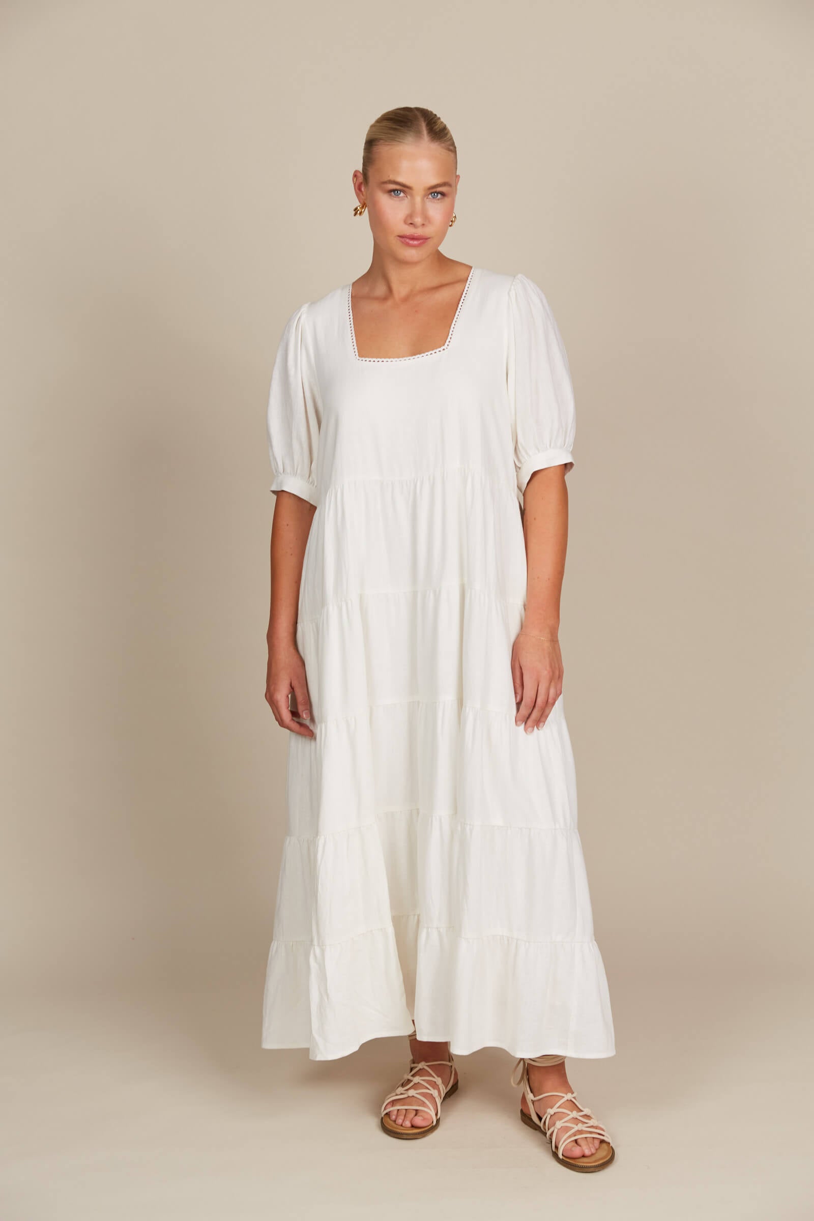 Model in white tired flowy dress