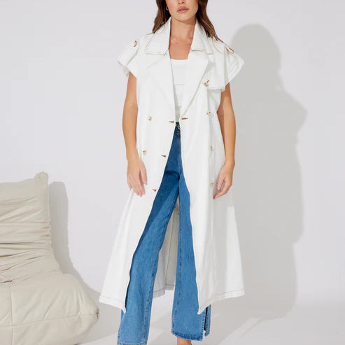 Woman in white denim longline vest and blue jeans