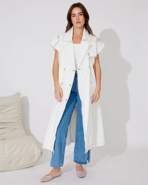 Woman in white denim longline vest and blue jeans