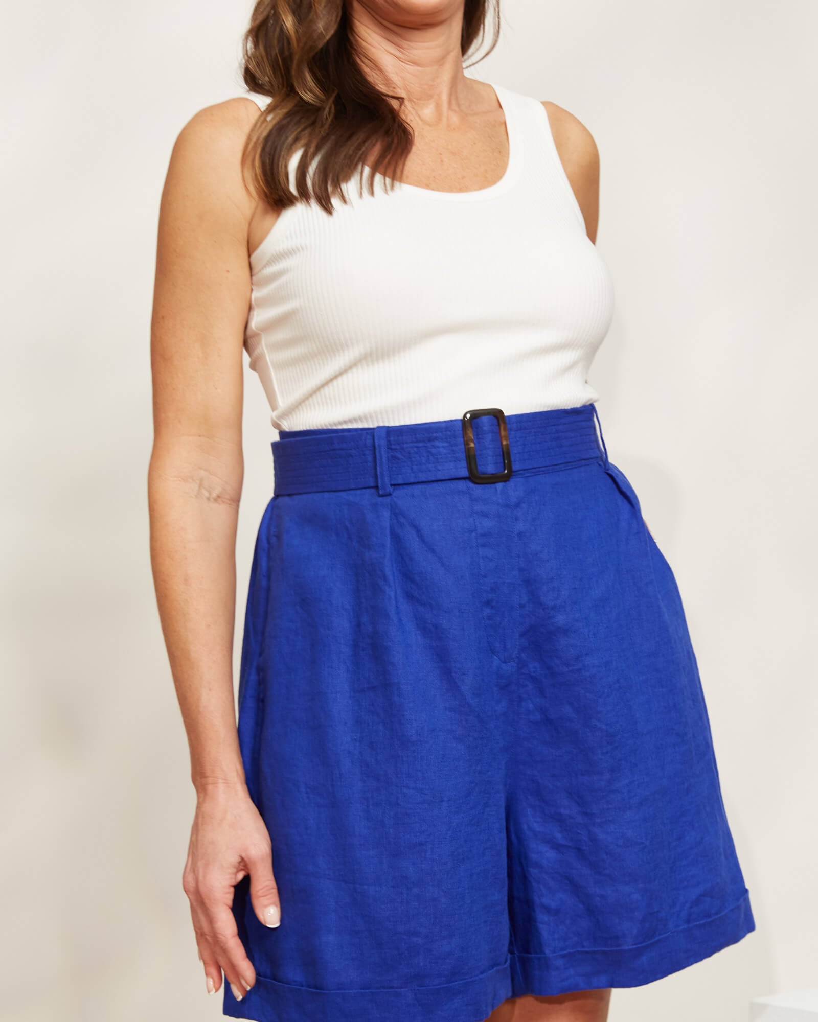 Model in blue shorts and white top