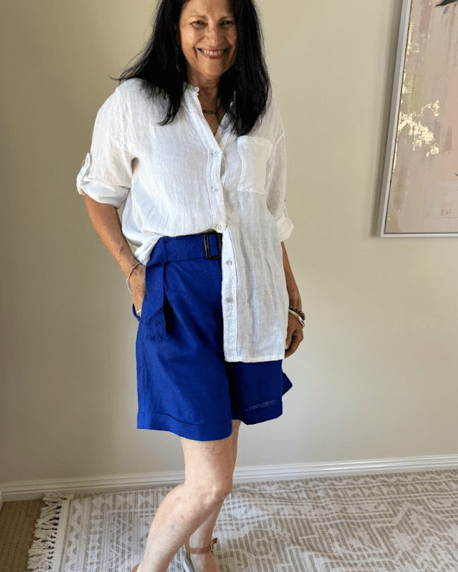 Lady smiling in white shirt and blue shorts