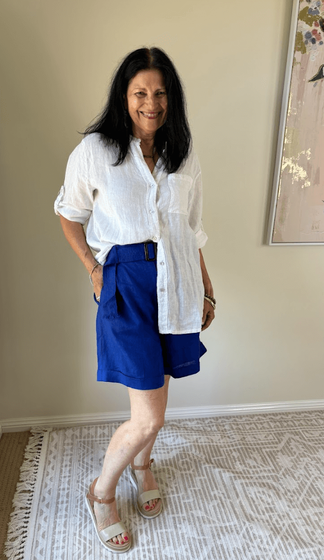 Lady smiling in white shirt and blue shorts