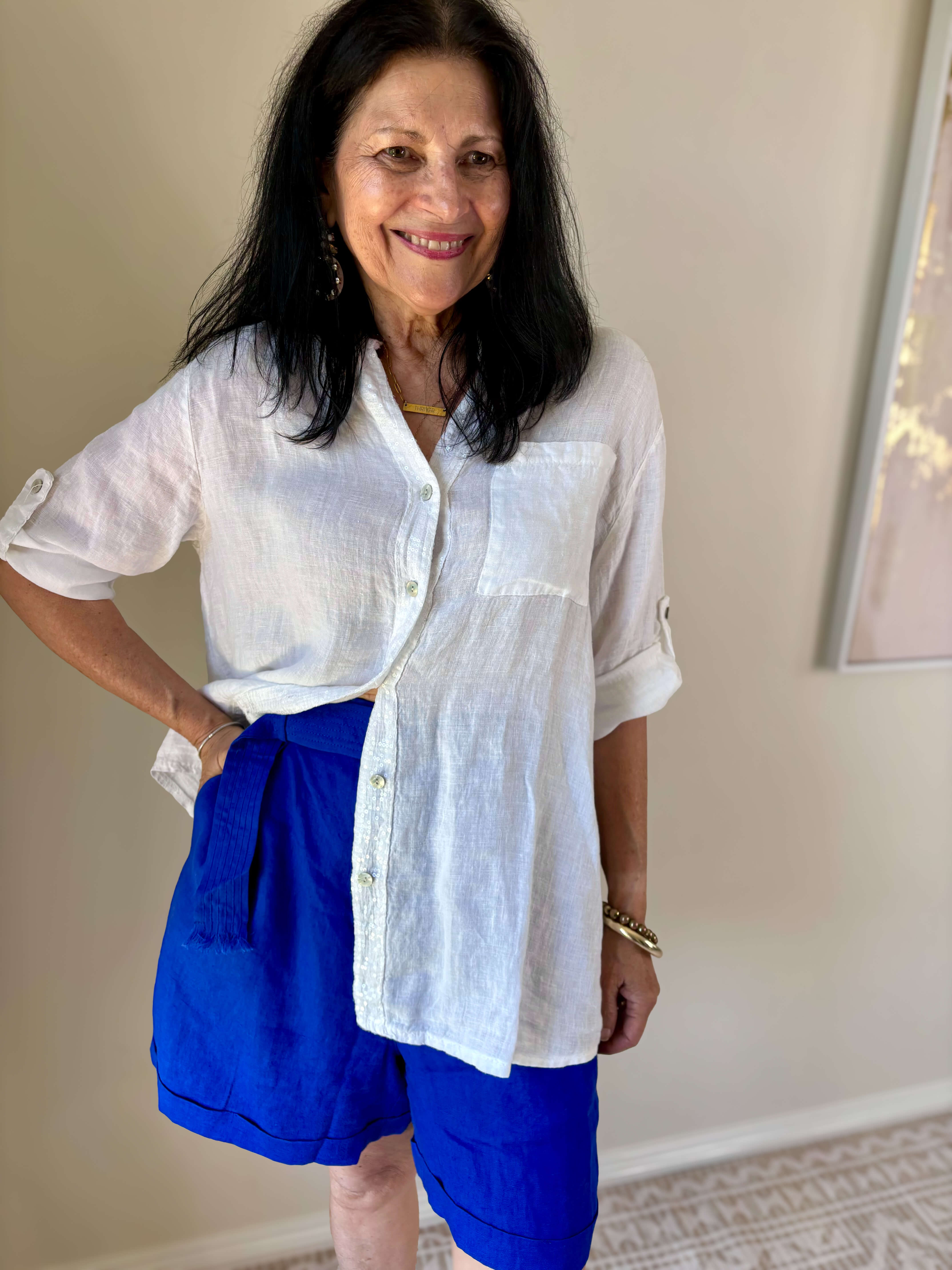 lady smiling in a white shirt and blue shorts