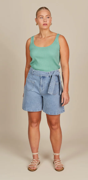 Model in blue shorts and green tank