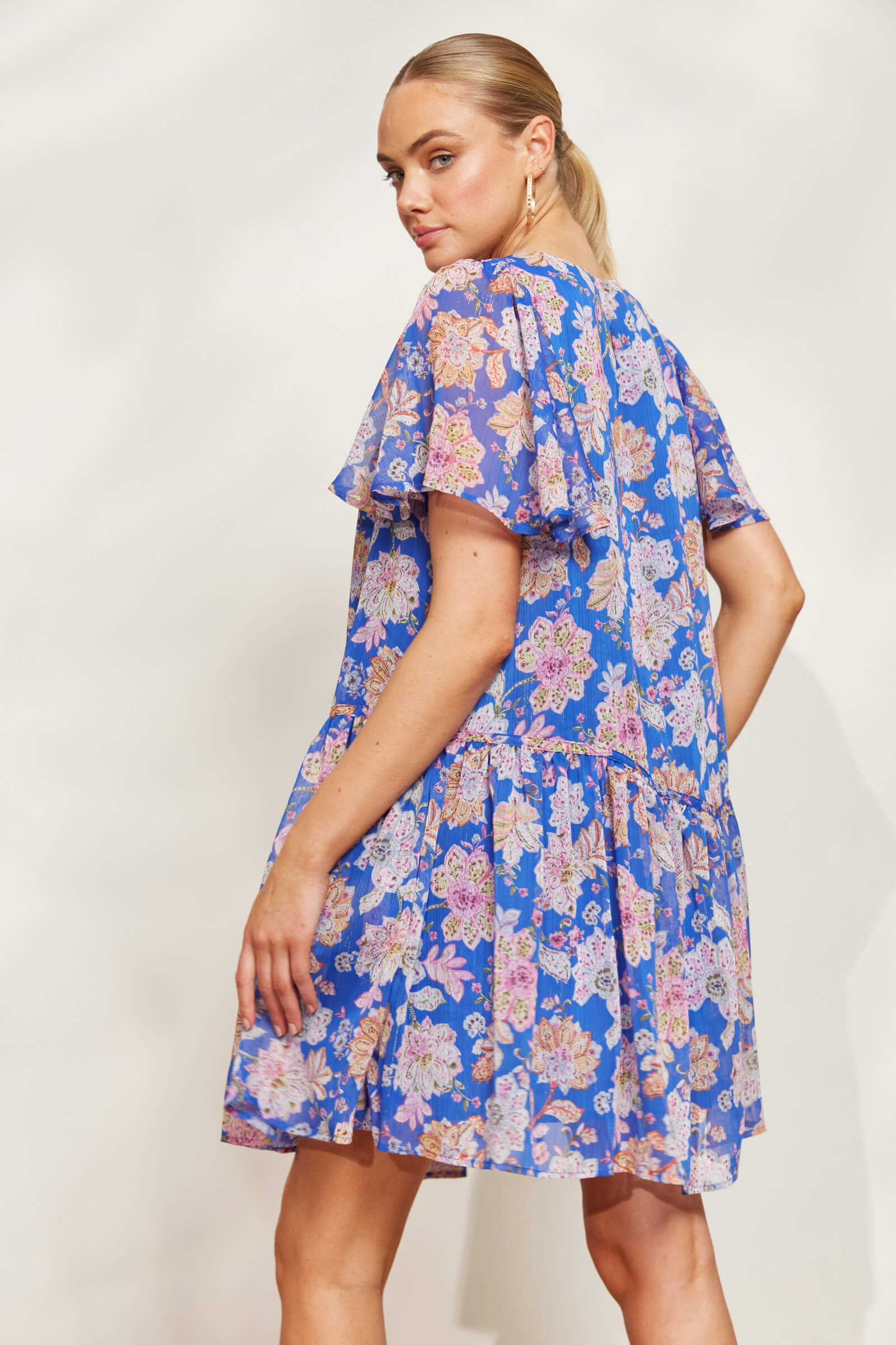 model posing in a blue lurex sparkle knee length dress