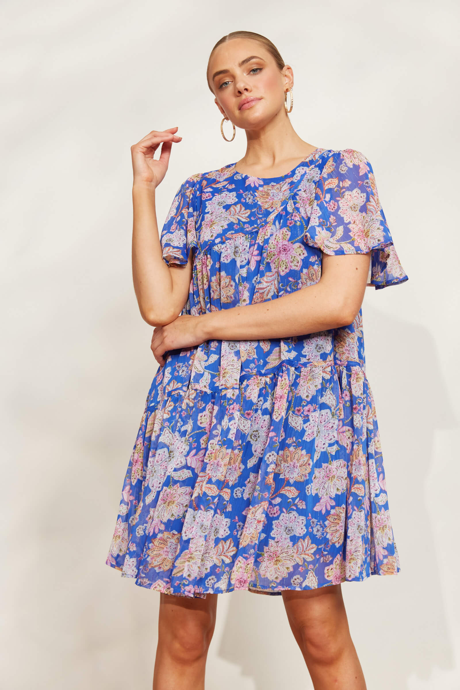 model posing in a blue lurex sparkle knee length dress