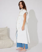 Woman in white denim longline vest and blue jeans