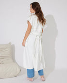 Woman in white denim longline vest and blue jeans