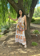 lady smiling in front of a tree in a maxi dress