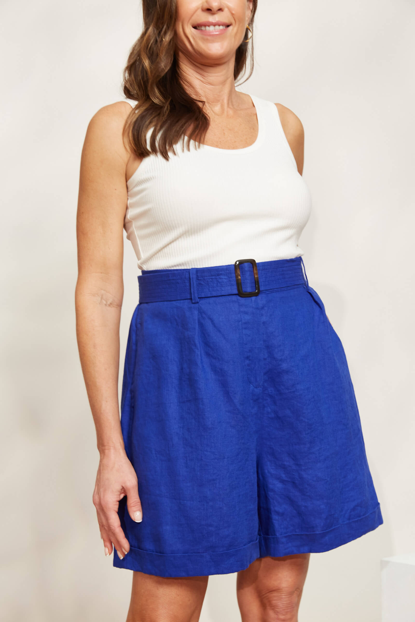 Model in blue shorts and white top